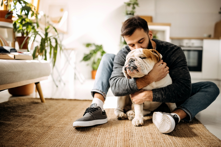 Man hugging a dog inside of the house